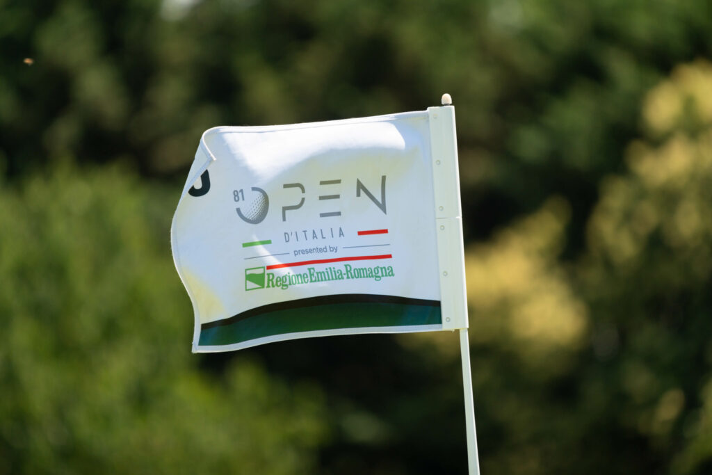 Bandiera dell'81° Open d'Italia sventola su un campo da golf, con il logo della Regione Emilia-Romagna. Evento sportivo internazionale di alto livello.